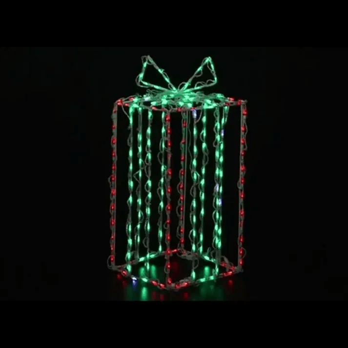 A three-dimensional gift box-shaped LED light decoration with glowing green, red, and white lights on a black background.