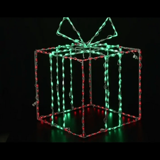 A wire-frame gift box holiday light decoration with glowing green and red LED lights, set against a solid black background.