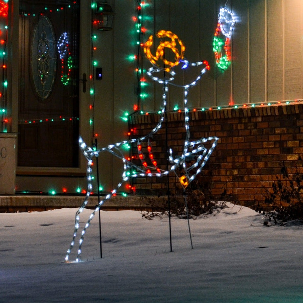 Leaping Reindeer LED Display with a green lighted tree in the snow